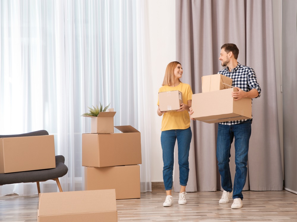 Couple,With,Moving,Boxes,In,Their,New,House